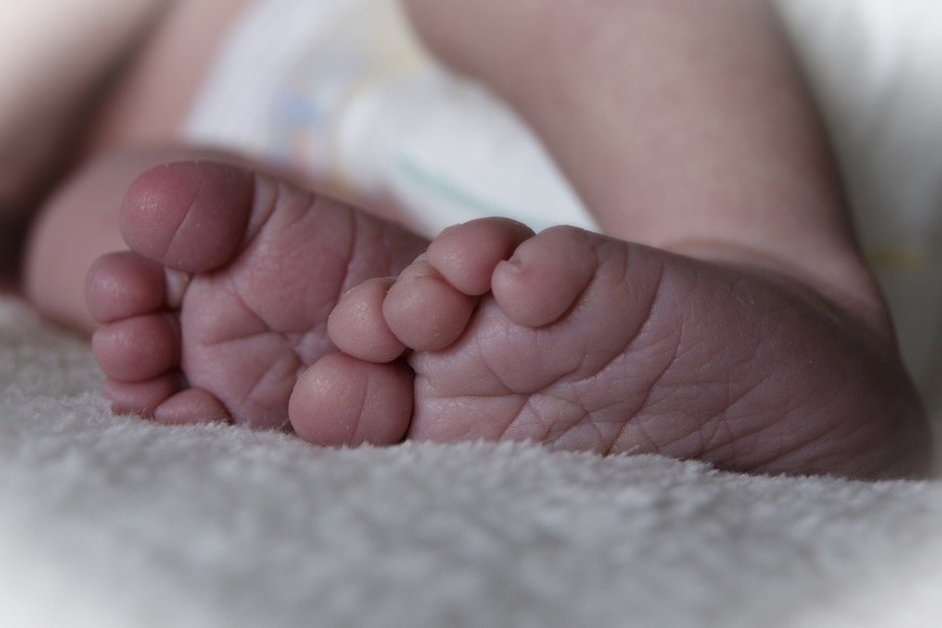Zdjęcie przedstawia małe stópki noworodka.