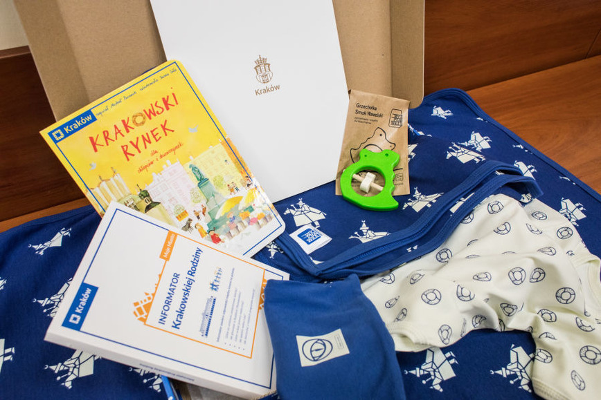 Zdjęcie przedstawia pakiet dla każdego nowo narodzonego dziecka: książki, ulotki, zabawkę, kocyk i ubranko. Fot. Bogusław Świerzowski